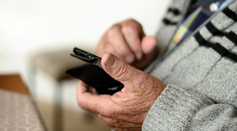 téléphone portable dans les mains d'une personne âgée